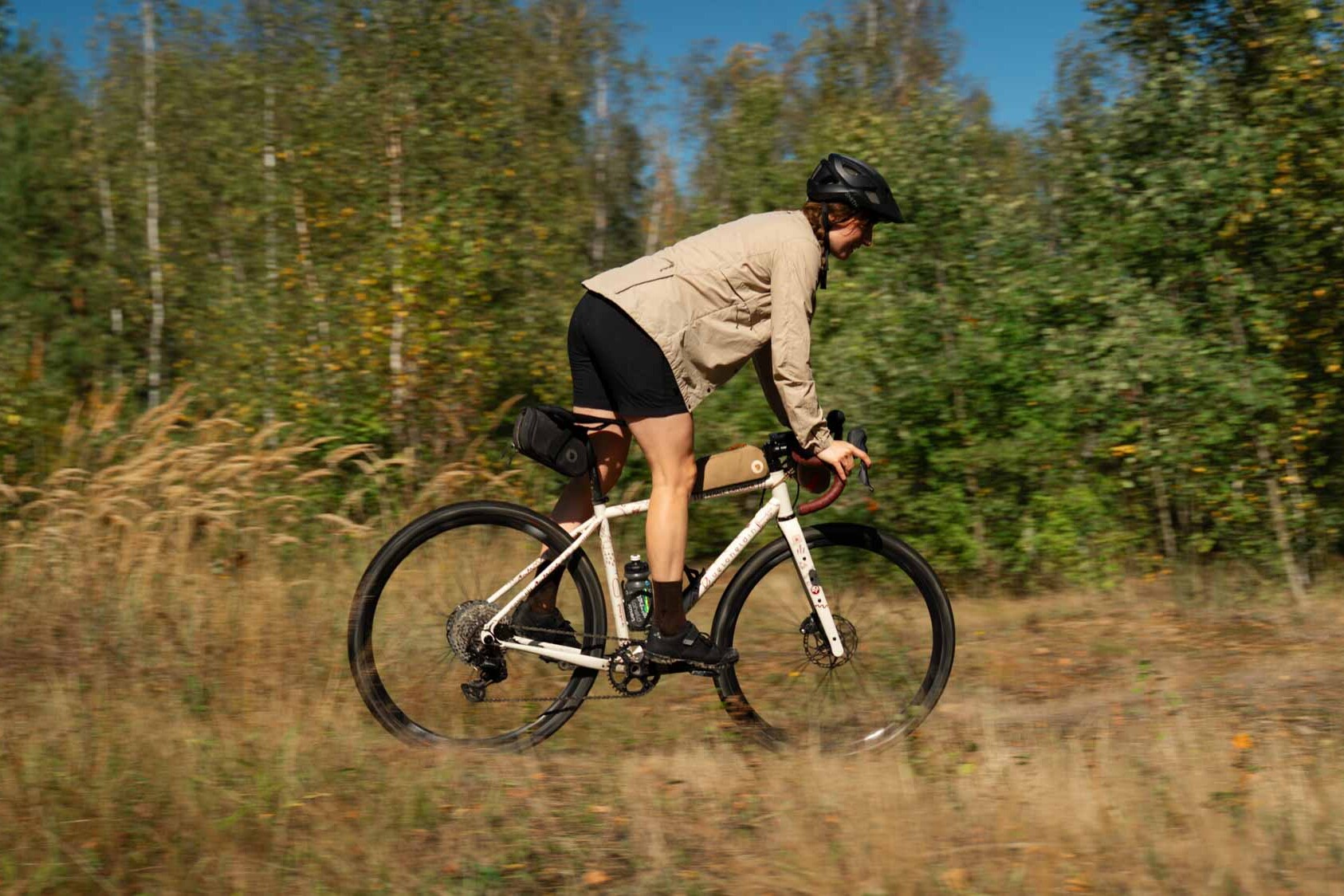 Frau in Action auf dem Rad, sie fährt durch den Wald