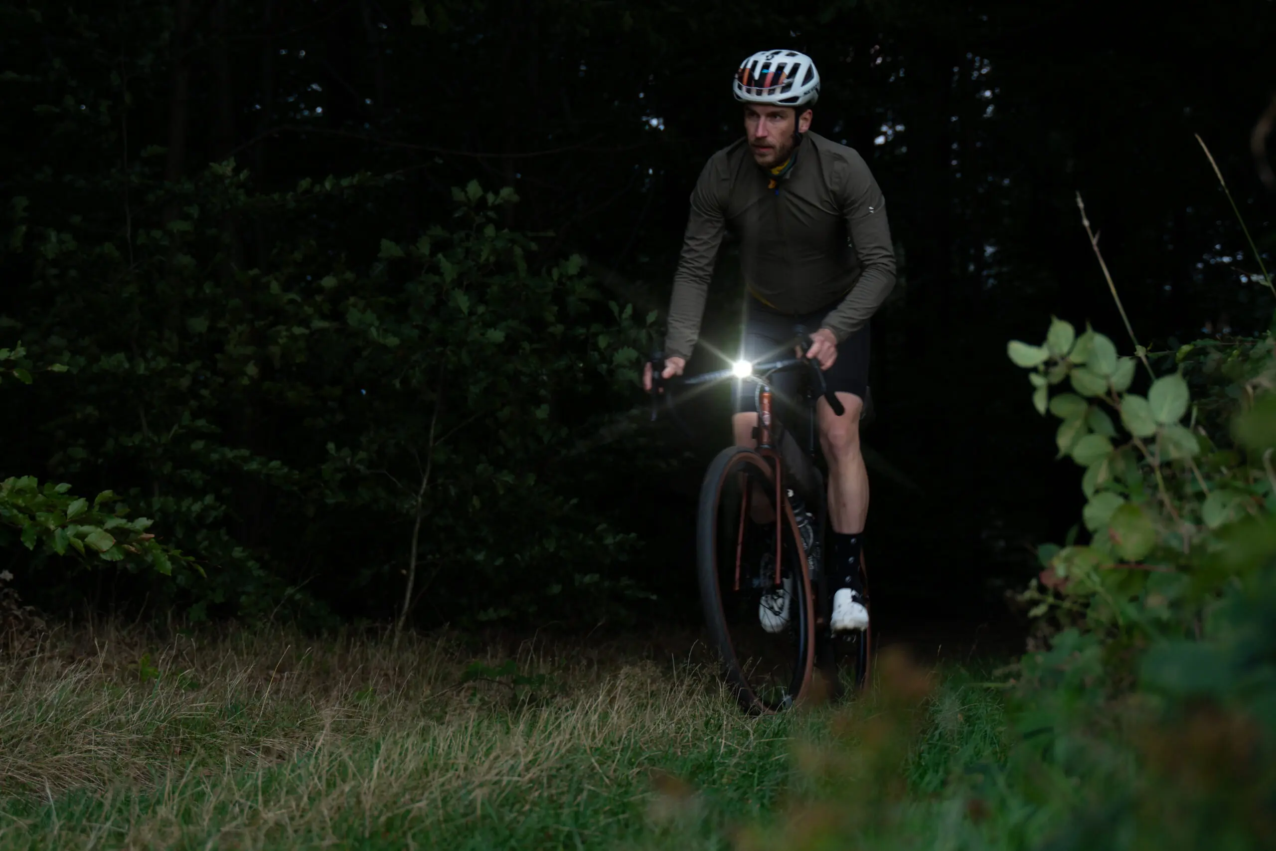 Gravelrad von veldheld im Wald mit hellen Licht am Lenker
