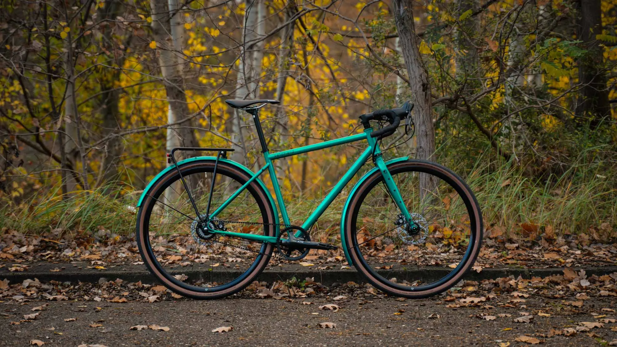 ein veloheld.alleyX Tourist in blaugrün steht vor vielen Bäumen